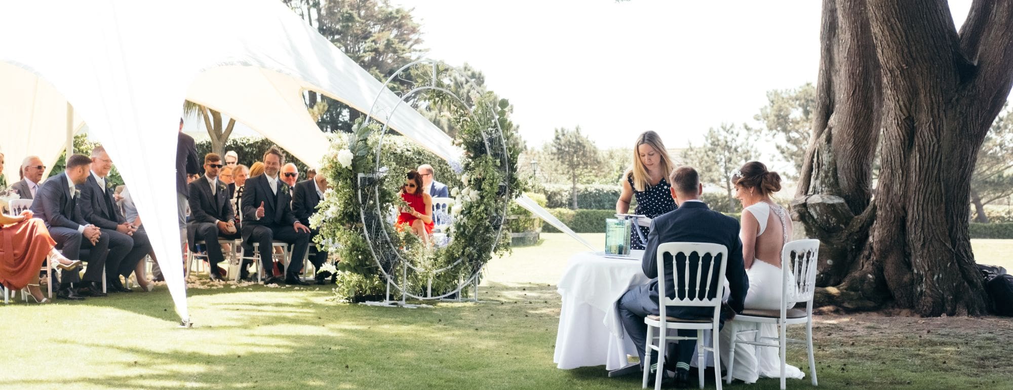 Jessica and Chris celebrate their wedding day at The Atlantic Hotel in a lush, outdoor setting with elegant decor.