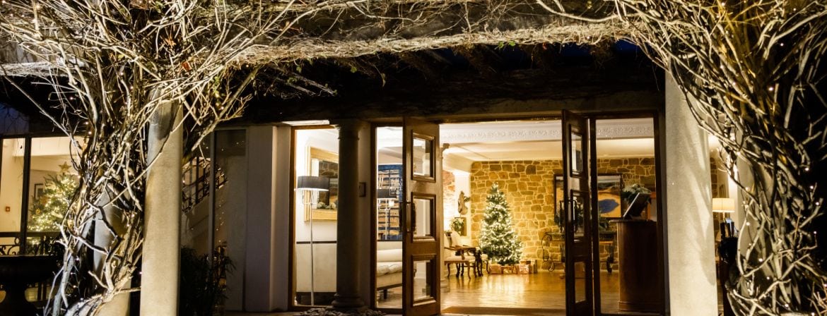 The grand entrance at The Atlantic Hotel in the festive period with fairy lights and a Christmas tree in the hotel lobby.